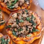 An absolutely delicious fall Whole30 dinner - Acorn Squash is roasted and stuffed with sausage and sautéd mushrooms and kale.