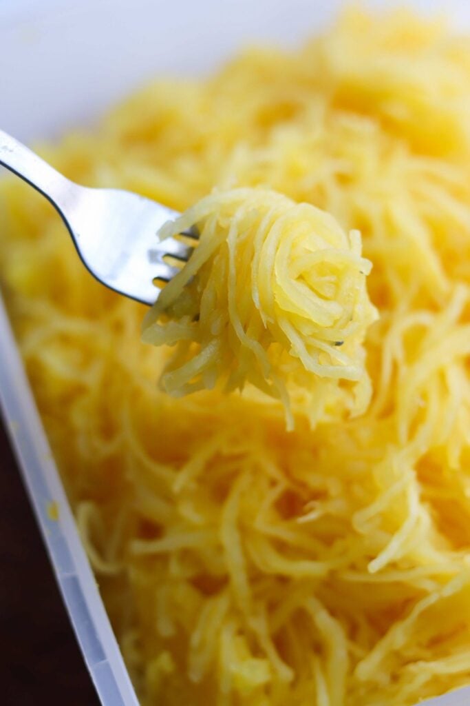 A fork holding up cooked, tender spaghetti squash