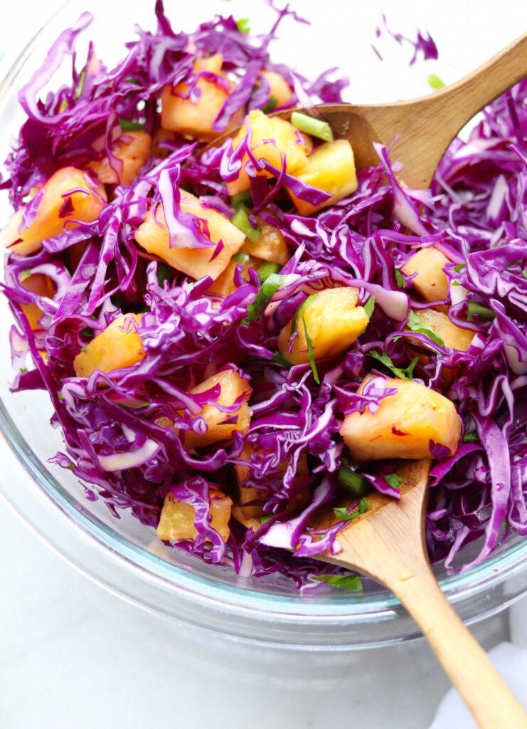The spicy pineapple and cabbage slaw, mixed together in a glass bowl.