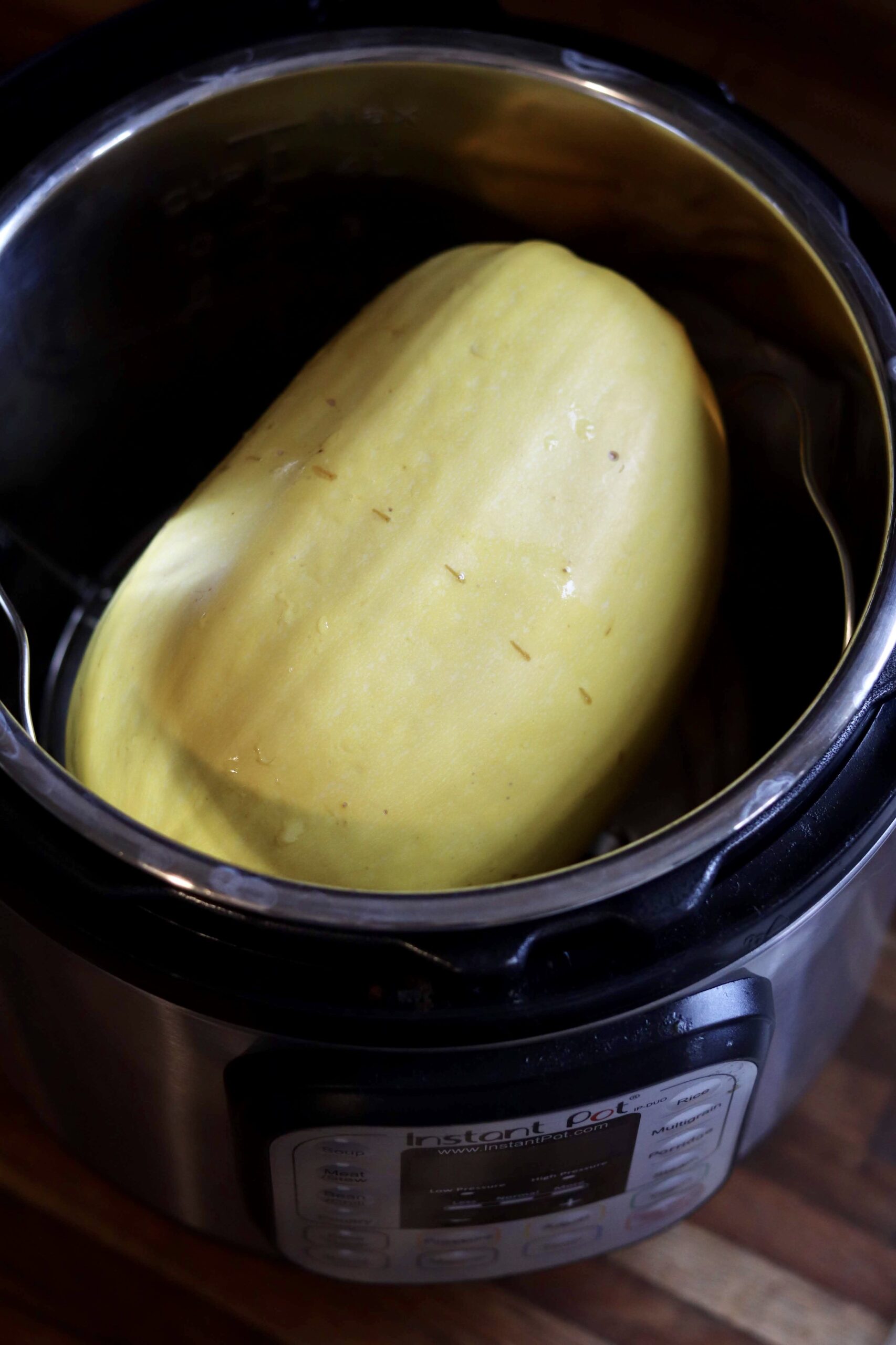 Whole spaghetti squash in an Instant Pot, ready to be cooked.