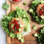 Finished Whole30 Turkey burgers served inside a lettuce wrap, topped with chipotle ketchup and sliced avocados