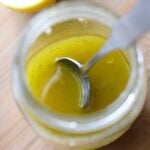 Close up of lemon dressing in a mason jar with a spoon
