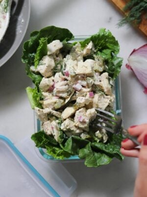A small glass dish filled with romaine lettuce and topped with dill pickle chicken salad