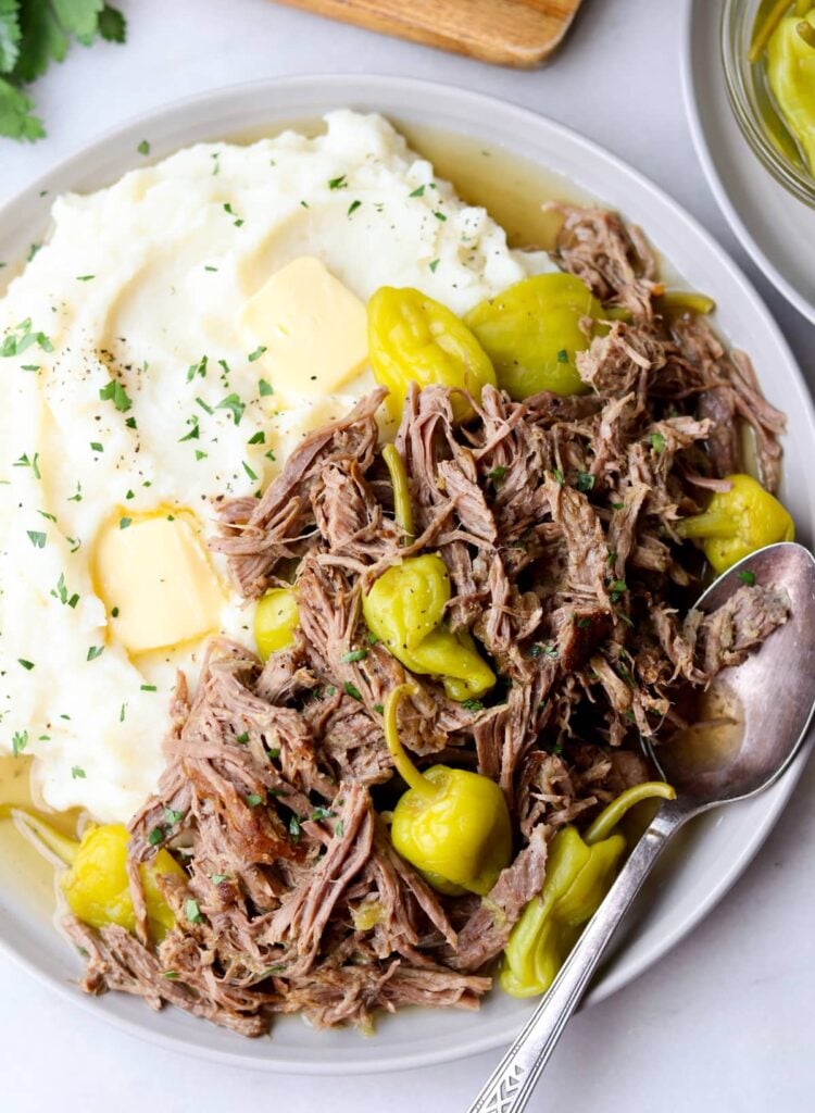 Close up of a plate filled with mashed cauliflower and ketogenic pot roast with pepperoncini.