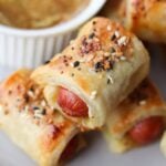 Close up of a few pigs in a blanket on a plate.