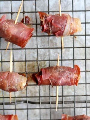 Close up of the cooked prosciutto wrapped dates on the baking sheet.