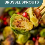 Close-up of a fork holding a halved roasted Brussels sprout with bacon, pomegranate seeds, and a maple mustard pork loin, accompanied by text reading "Maple Bacon Brussel Sprouts.