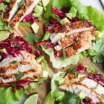 Cooked marinated grilled chicken thighs served on lettuce wraps.