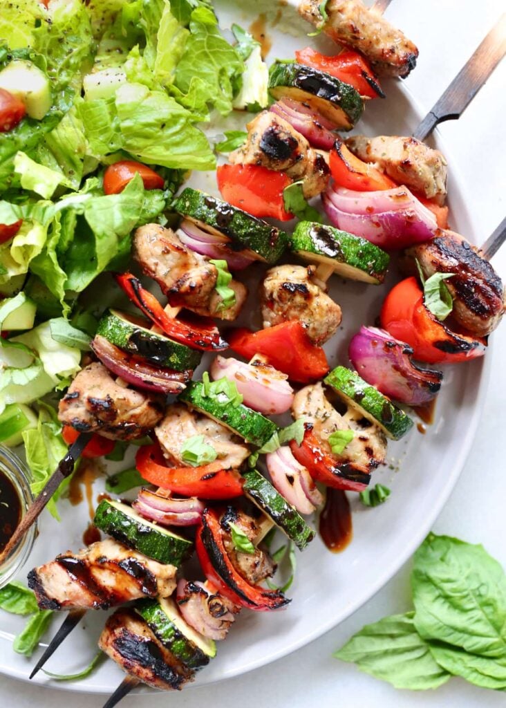 Plated pork kebabs with bell peppers, red onion, and zucchini.