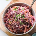 The cabbage and carrot slaw plated in a gray bowl.