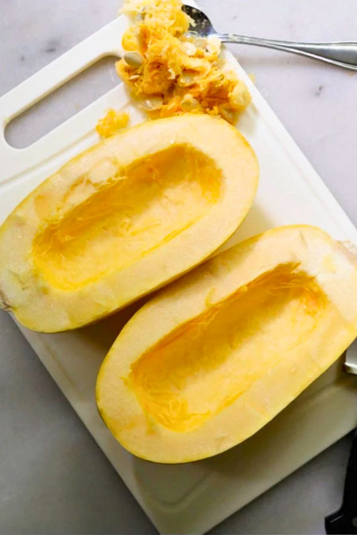 A spaghetti squash cut in half lengthwise with seeds removed.
