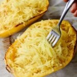 Close up of a cooked spaghetti squash with a fork.