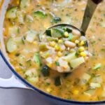 A ladle over a pot of white bean chili.