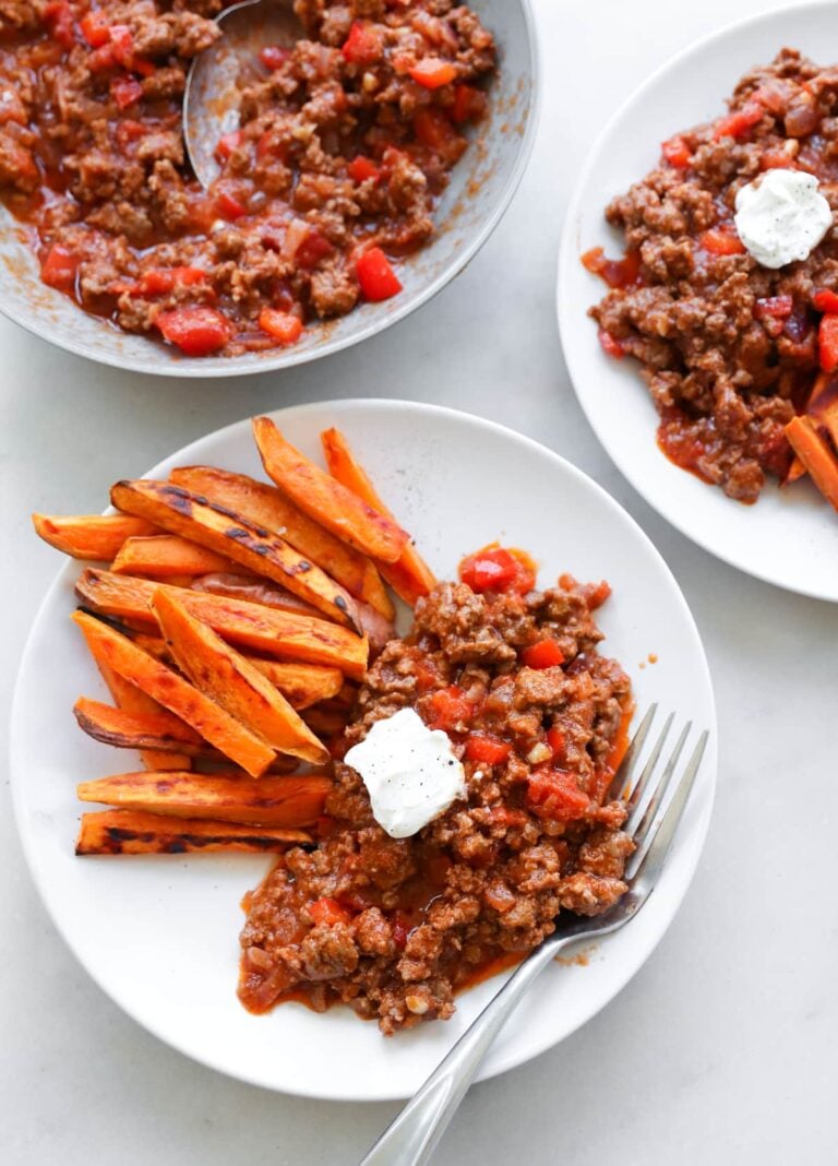 Healthy sloppy Joes and sweet potato fries on two white dinner plates.