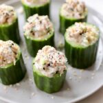 Close up of filled tuna cucumber cups on a gray plate.