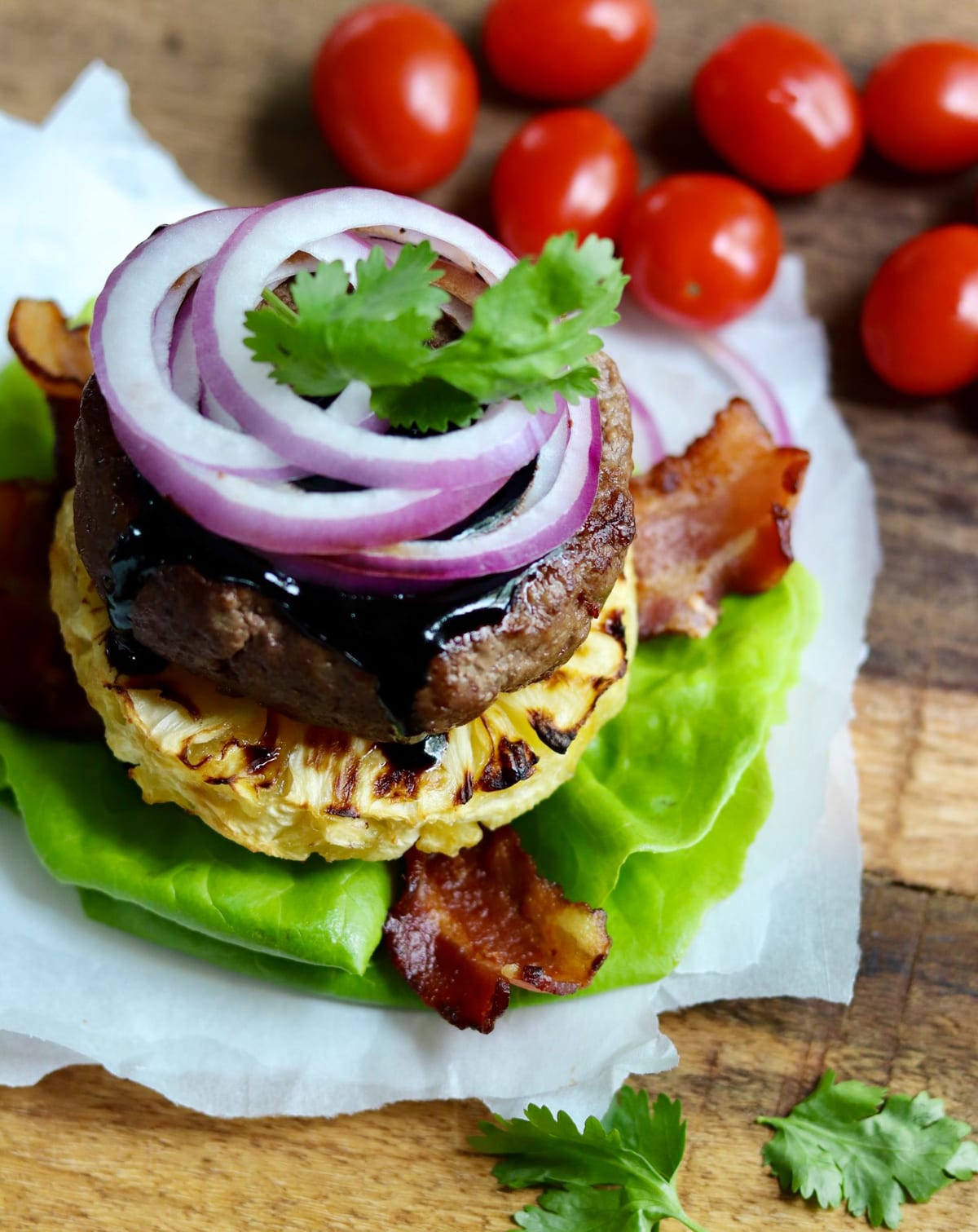 Top view of the Aloha burger topped with red onion, bacon, and grilled pineaapple. 