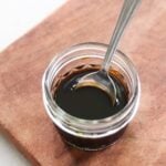 A small glass jar and spoon with soy-free teriyaki sauce.