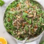 A large gray bowl filled with quinoa and arugula salad.