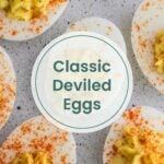 Overhead view of several deviled eggs sprinkled with paprika on a light speckled surface, with the text "Classic Deviled Eggs" overlaid in the center—perfect alongside apple pie overnight oats for a delicious brunch spread.
