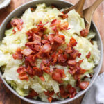 Plated sautéed cabbage topped with crispy bacon.
