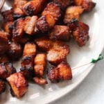 A white serving platter full of crispy pork belly bites.