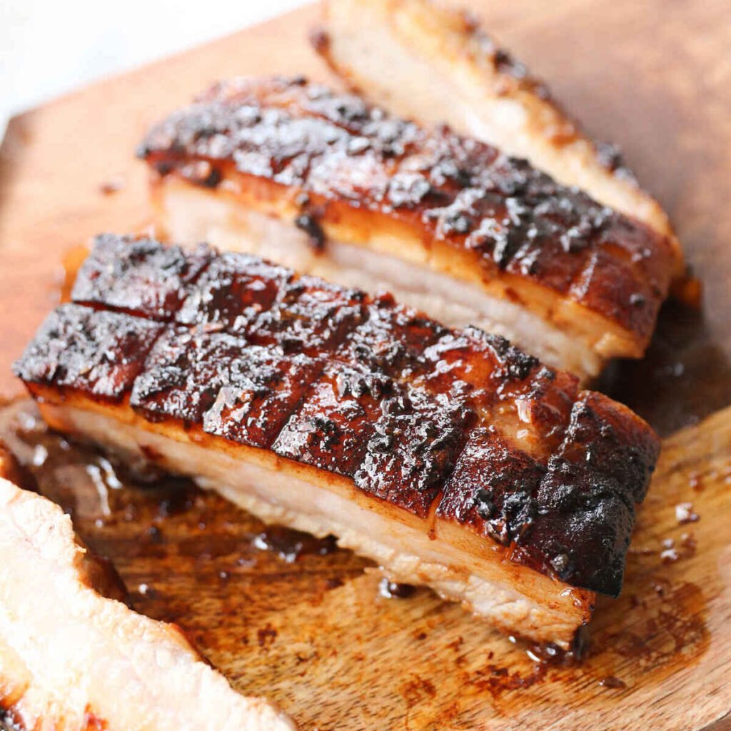 Honey glazed bbq pork ribs on a cutting board.