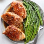 Plated brown sugar pork chops with asparagus.