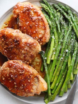 Plated brown sugar pork chops with asparagus.