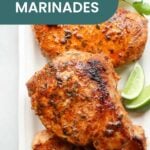 Three seasoned pork chops on a plate garnished with herbs and lime wedges, showcasing the best pork chop marinade. Text overlay reads "Best Pork Chop Marinades.