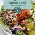 Discover the Big Mac salad bowl: a delightful mix of ground beef, crispy bacon, pickles, red onion, avocado, lettuce, and sesame seeds drizzled with dressing. Perfect for those looking to elevate their culinary adventures! Find more ideas at cookathomemom.com.