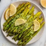 Air-fried asparagus with lemon and parmesan on a plate.