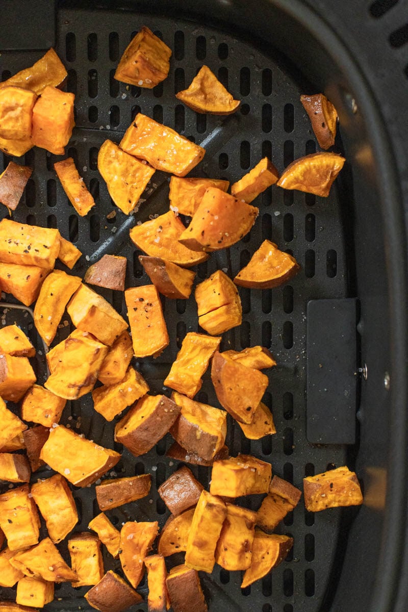 Chunks of root vegetables in an air fryer basket.