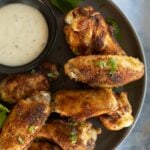 A plate of air fryer chicken wings served with dipping sauce.
