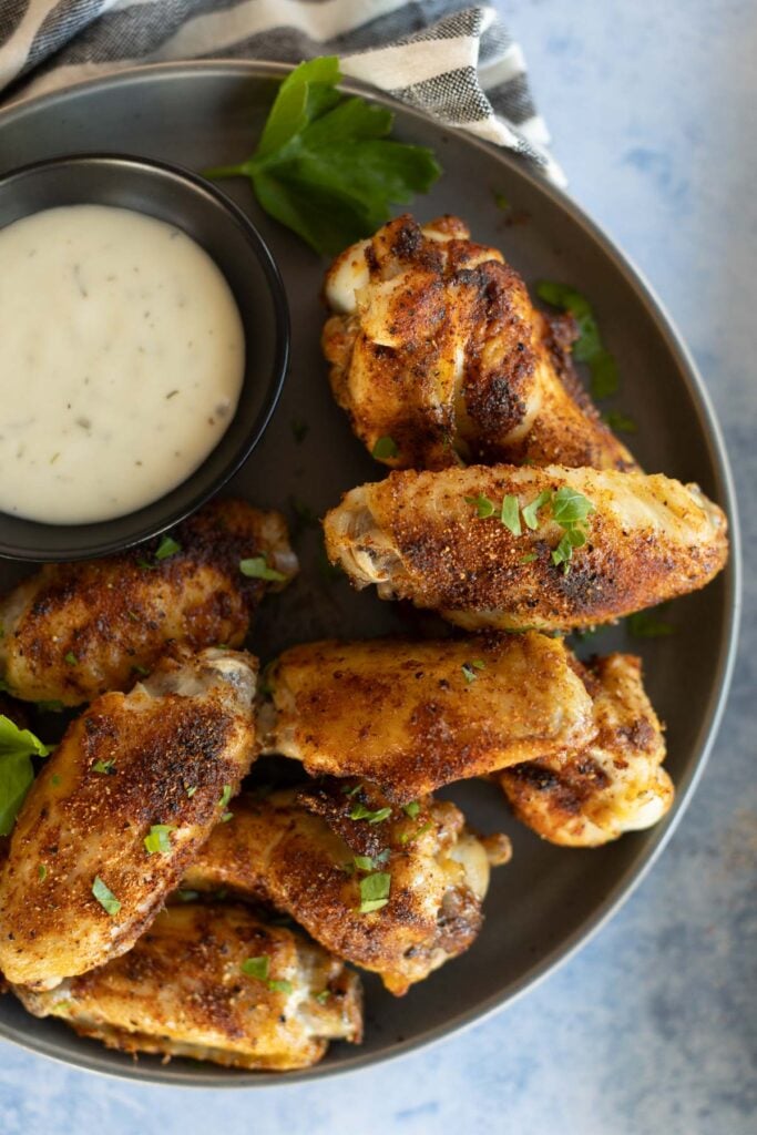 A plate of air fryer chicken wings served with dipping sauce.