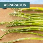 A bunch of fresh asparagus spears on a wooden cutting board, with text reading "how to freeze asparagus" for easy meal prep, and "cook at home mom.