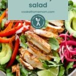 A bowl of chicken fajita salad with dutch oven chicken strips, sliced bell peppers, avocado, pickled onions, lime, and leafy greens is labeled "chicken fajita salad.