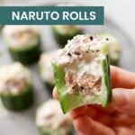 A hand holds a cucumber roll filled with a creamy mixture, while air fryer hot dogs and similar rolls rest on a blurred plate in the background. Text reads "easy NARUTO ROLLS" and "cook at home mom.
