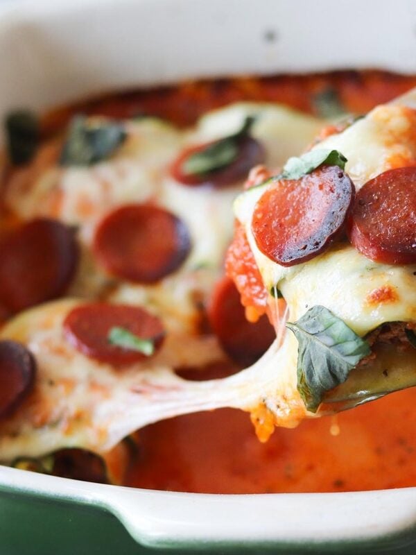 Baked zucchini rollups in a white casserole dish.