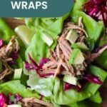 Pork lettuce wraps topped with shredded pork, creamy avocado, and crisp purple cabbage are served on fresh green lettuce leaves, viewed from above.