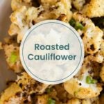 Close-up of roasted cauliflower florets garnished with chopped green onions, with a text overlay reading "Roasted Cauliflower" highlighting this delicious roasted cauliflower dish.