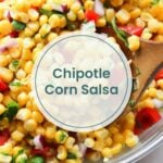 A bowl of chipotle corn salsa with corn, red onion, red pepper, and cilantro, shown with a wooden spoon—perfect as a fresh topping for oven baked salmon in foil. Text overlay reads "Chipotle Corn Salsa.