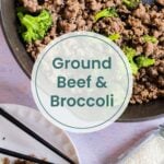 A skillet with ground beef and broccoli sits beside a plate, chopsticks, and a jar of sesame seeds. Text overlay reads "Ground Beef & Broccoli.