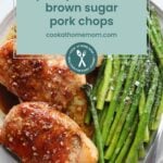 Two pan-seared pork chops with brown sugar glaze served alongside asparagus on a white plate; text overlay reads "quick pan seared brown sugar pork chops." Try our baked BBQ chicken thighs for another easy, flavorful dinner option.