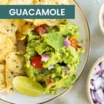 A plate of tortilla chips with easy guacamole topped with red onion, tomato, cilantro, and a lime wedge; bowls of lime, onions, and salsa on the side. Text reads "easy GUACAMOLE.