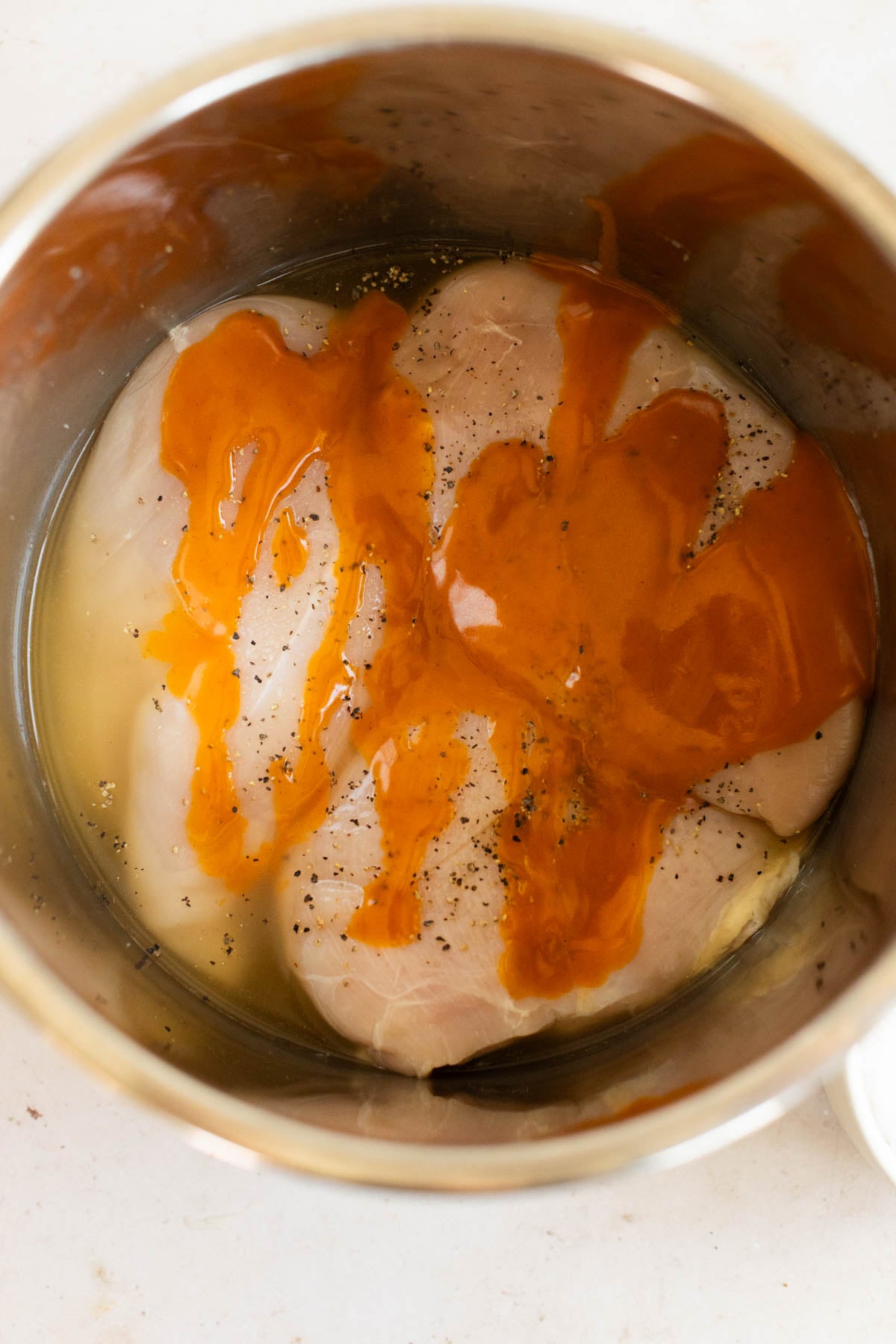 Uncooked buffalo chicken in Instant Pot.