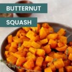 A plate of air fryer butternut squash cubes garnished with fresh herbs, with the text "air fryer butternut squash" overlaid on the image.