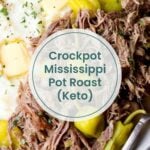 Plate featuring shredded crockpot Mississippi pot roast, pepperoncini peppers, mashed cauliflower, and butter. Text overlay reads "Crockpot Mississippi Pot Roast (Keto)".