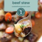 A close-up of a spoonful of beef stew with carrots and potatoes, with a bowl of stew in the background. Text overlay reads, "Dutch oven beef stew & brats in oven, cookathomemom.com.