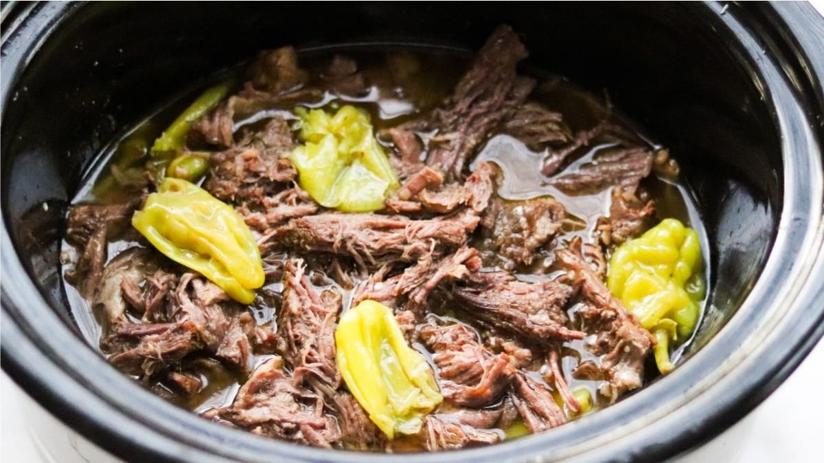 Shredded beef with pepperoncini peppers in broth, cooked in a crockpot.