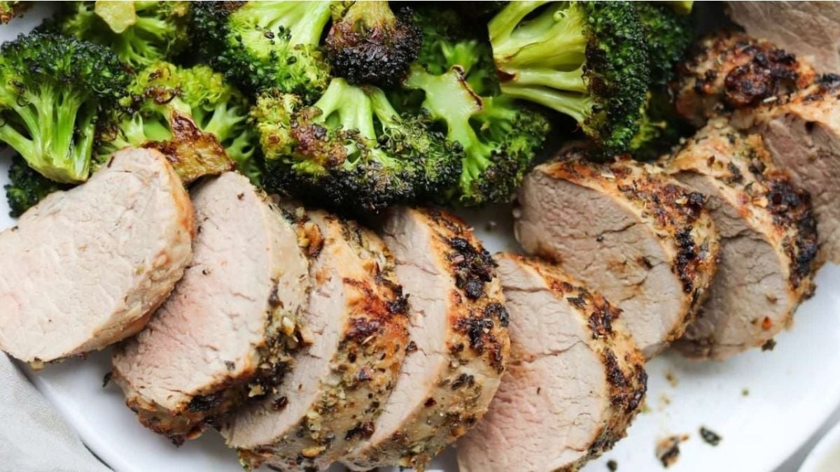 Slices of white meat on a platter with cooked broccoli florets.